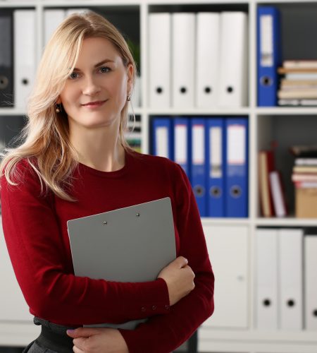 Portrait of cute blonde young office worker with documents posing in stylish outfit. Smart secretary going to bring paper to boss. Business, clerk concept
